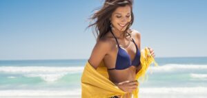 Happy woman with scarf at beach