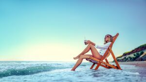 Pretty woman relaxing on a lounger beach and drinks soda water. summer vacation concept
